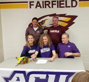 Senior Braden Bossier signs in front of her family, coaches, and friends. Photo by Kathie Maciel.