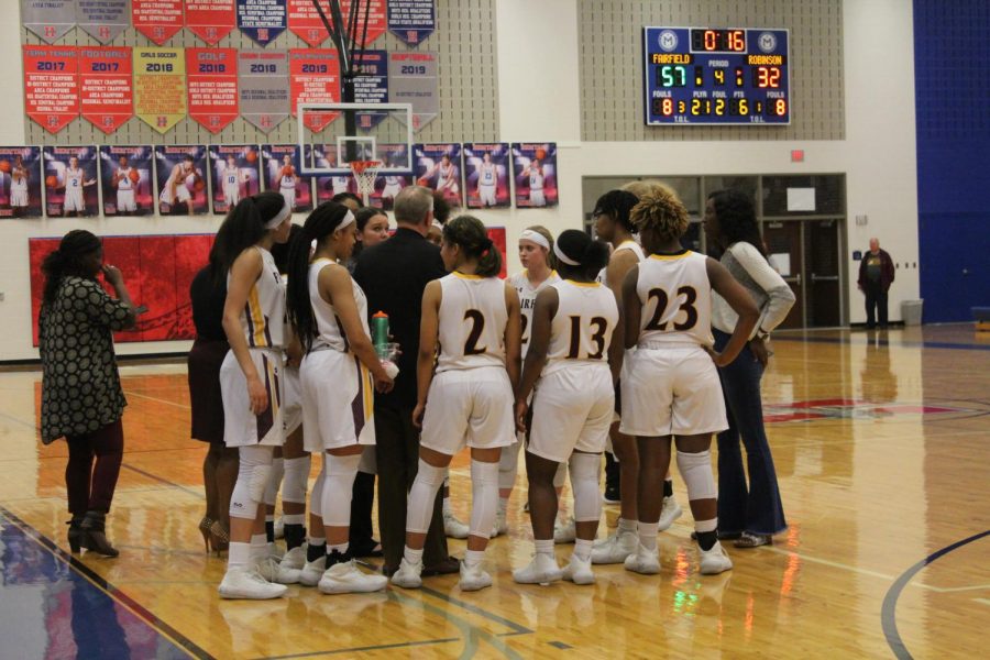 Lady Eagles call a time out to plan their strategy for the game. Photo by Cate Scott.